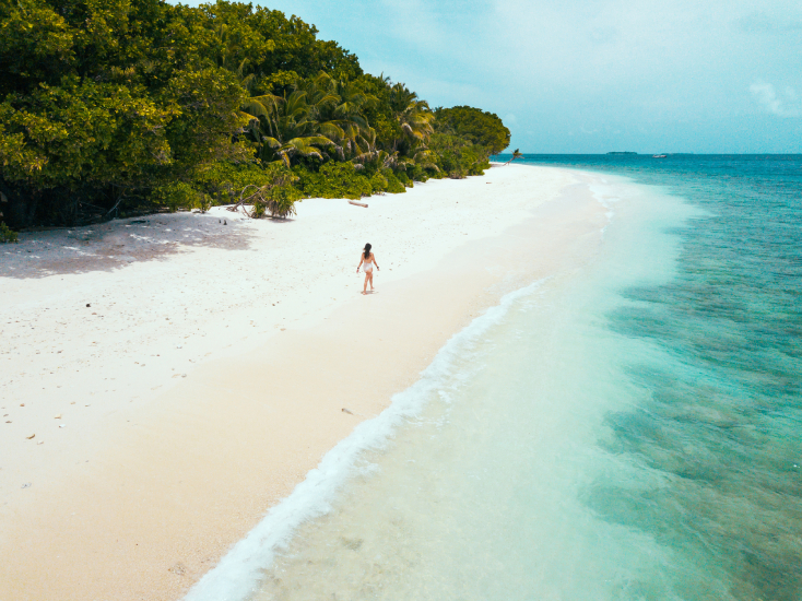 Woman walking on a paradisiac beach in Maldives